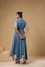 Back view of the Daisydrift Handkerchief Dress featuring a flowing handkerchief hemline, short sleeves, and gathered waist detail in lightweight denim.