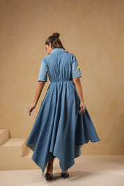 Back view of the Daisydrift Handkerchief Dress featuring a flowing handkerchief hemline, short sleeves, and gathered waist detail in lightweight denim.