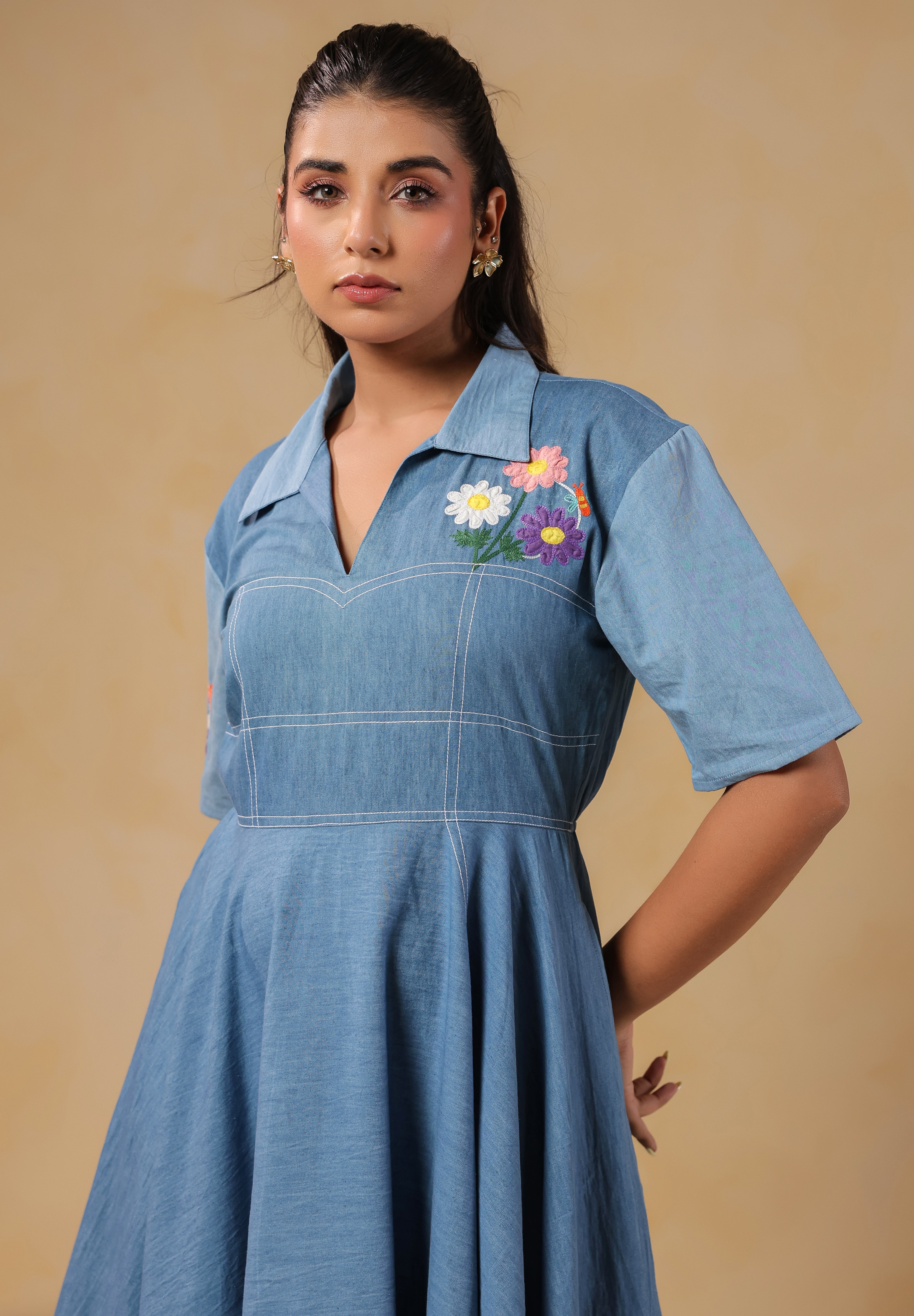 Zoomed-in view of the neckline and chest embroidery of the Daisydrift Handkerchief Dress, highlighting its collared V-neck and vibrant stitched daisies.