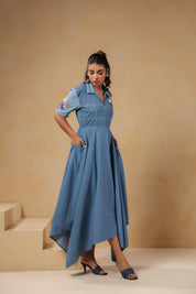 Model walking in the Daisydrift Handkerchief Dress, showcasing the asymmetrical hem and flowing fabric that moves gracefully with each step.