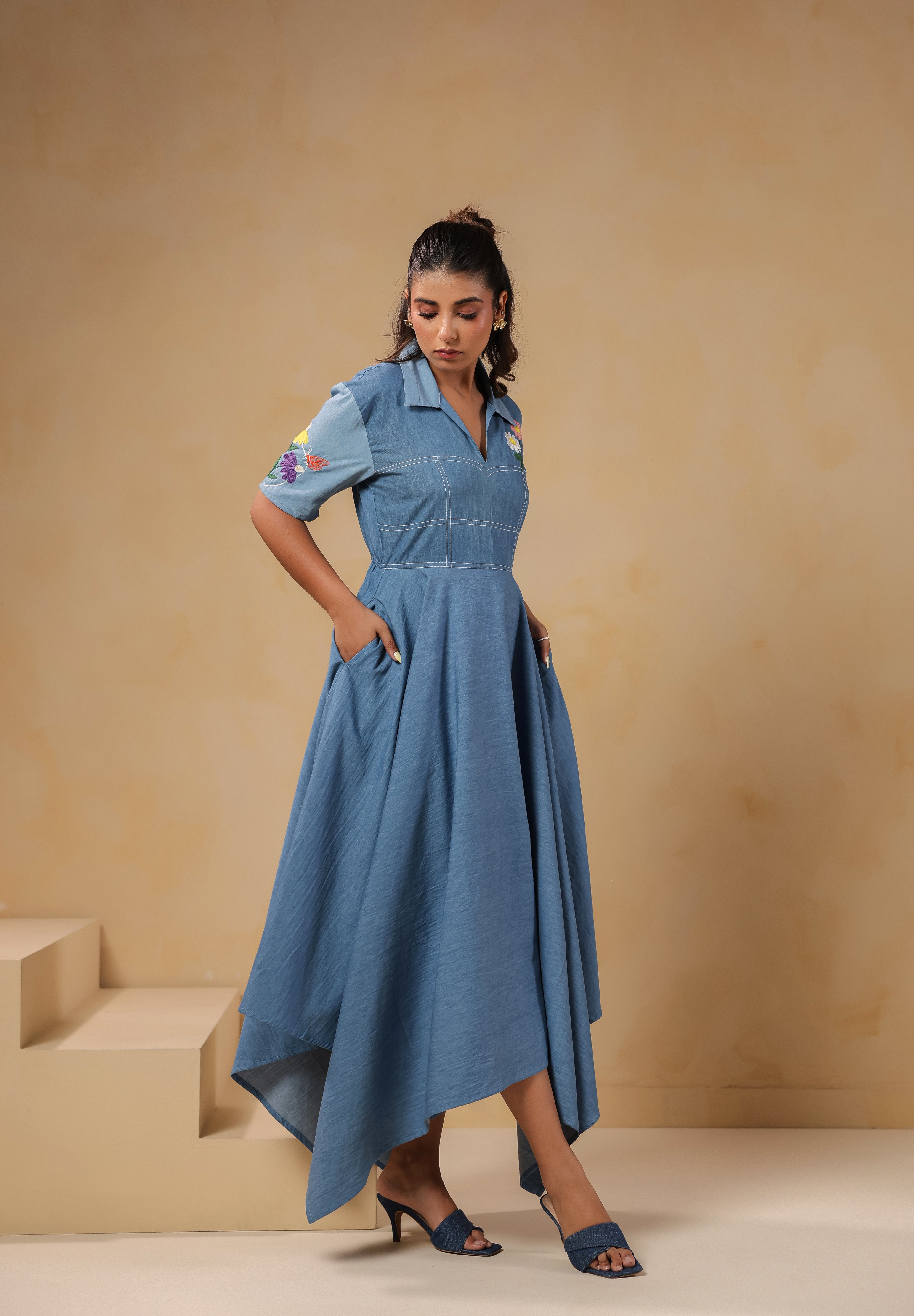 Model walking in the Daisydrift Handkerchief Dress, showcasing the asymmetrical hem and flowing fabric that moves gracefully with each step.