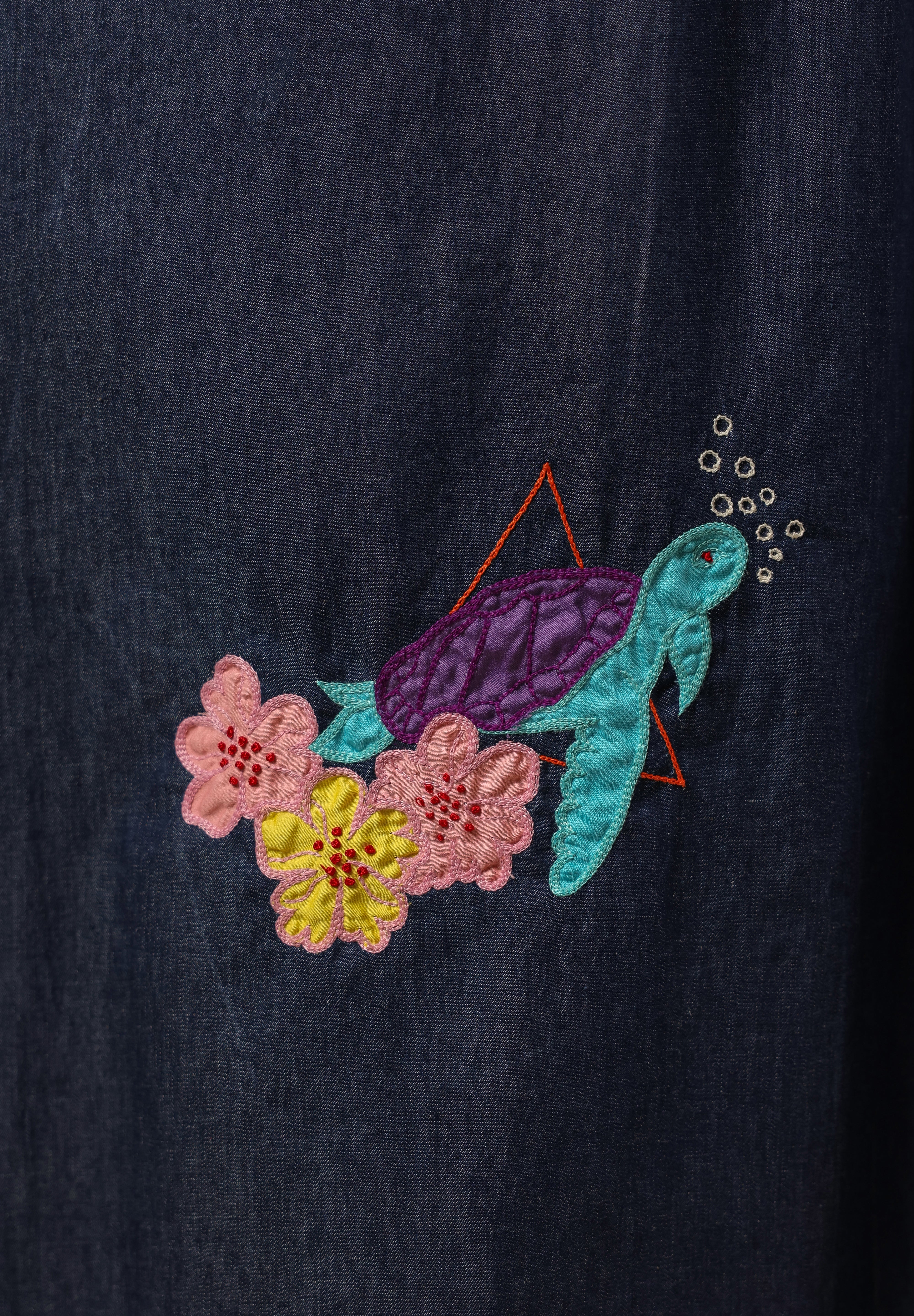 Detailed embroidery of turtle and flowers on lower skirt of Aqua Prism Midi Dress