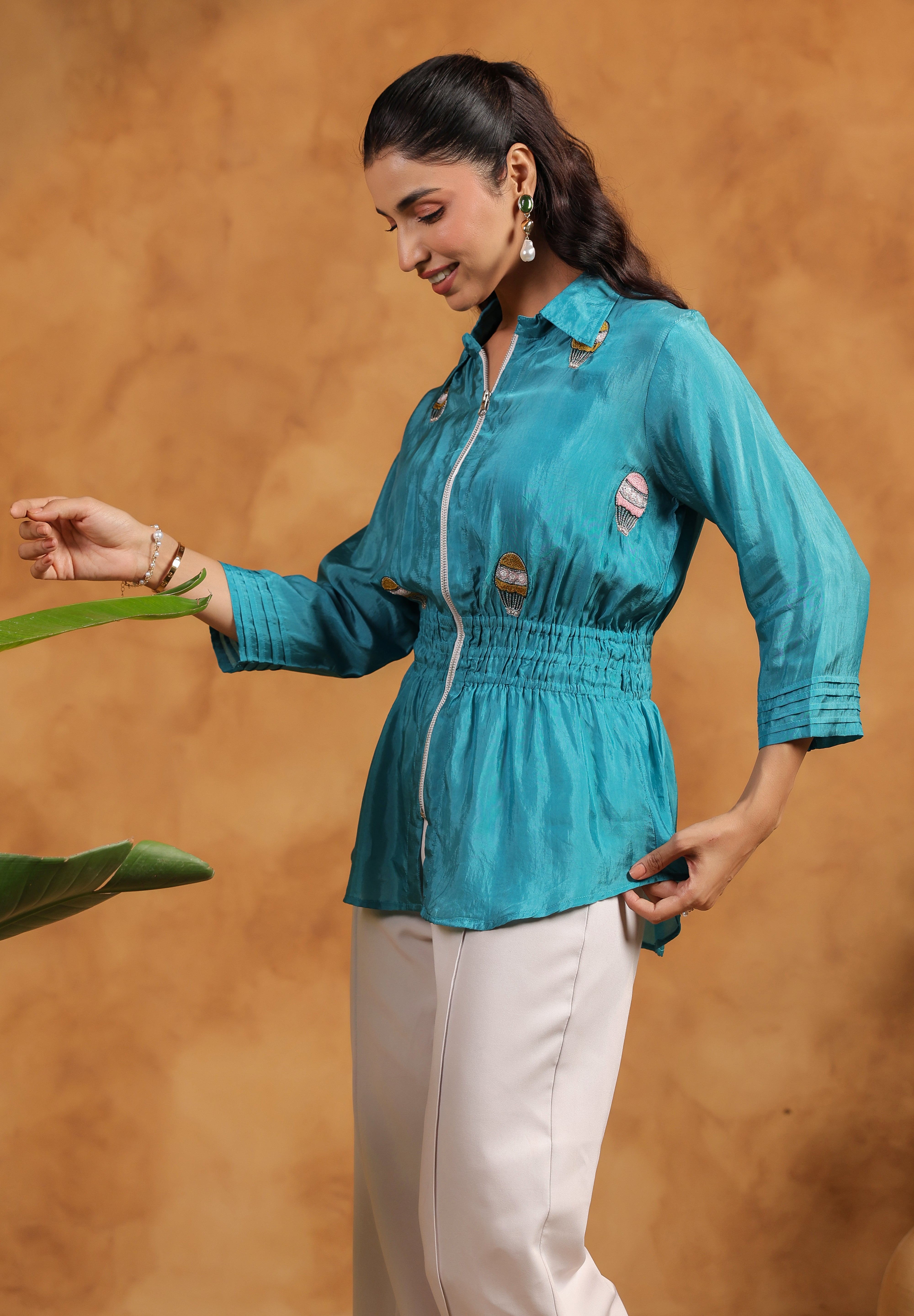 Woman wearing a teal shirt with a brown background
