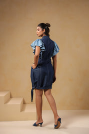 Back view of Ridah's Florablock Zip Mini Dress in breathable denim featuring soft flutter sleeves and a tie-up hem