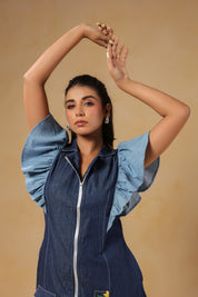 Playful hands-up pose highlighting flutter sleeves and modern denim silhouette