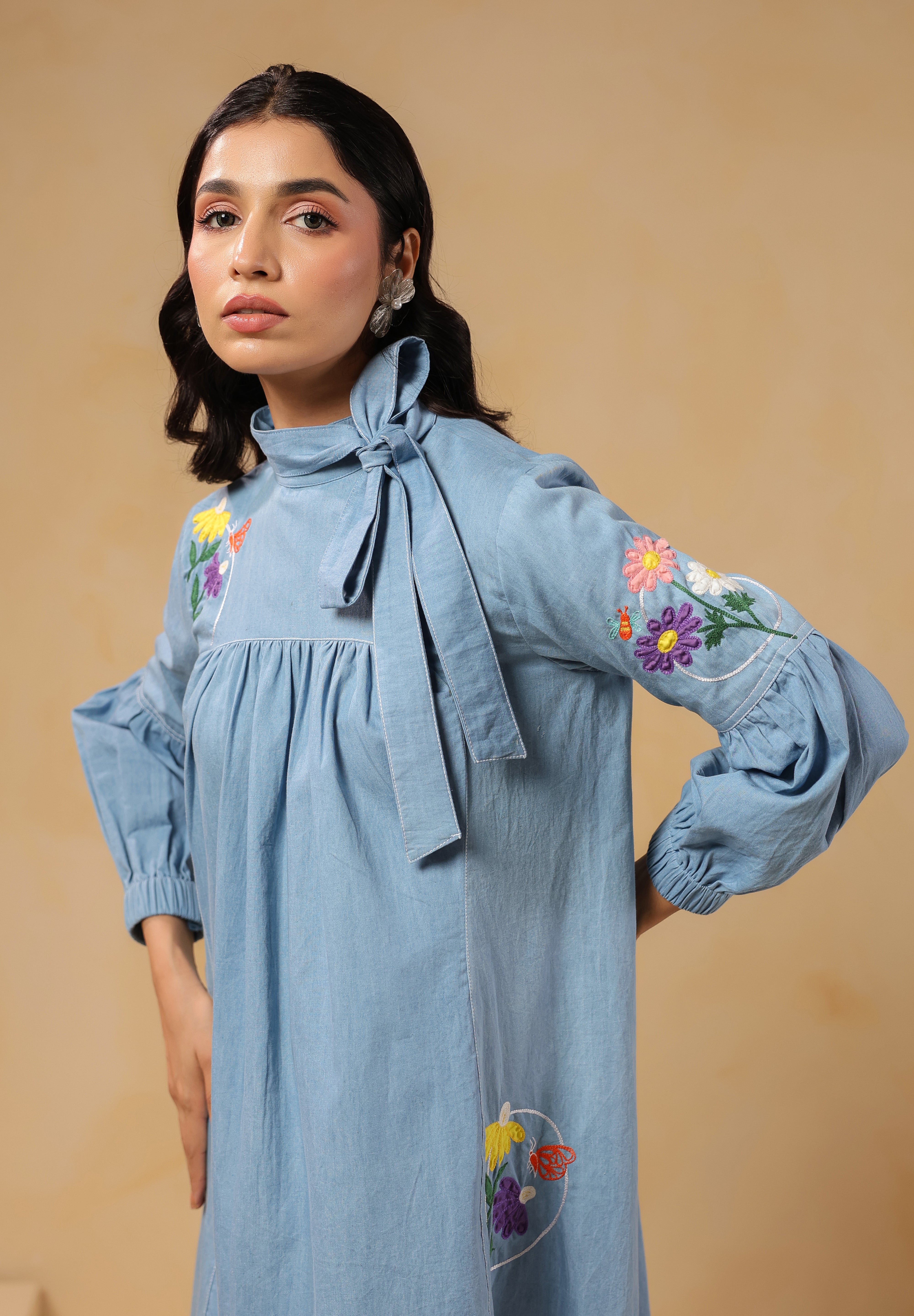 Detailed view of embroidered flowers and butterfly on sleeve of Floraverse Dress