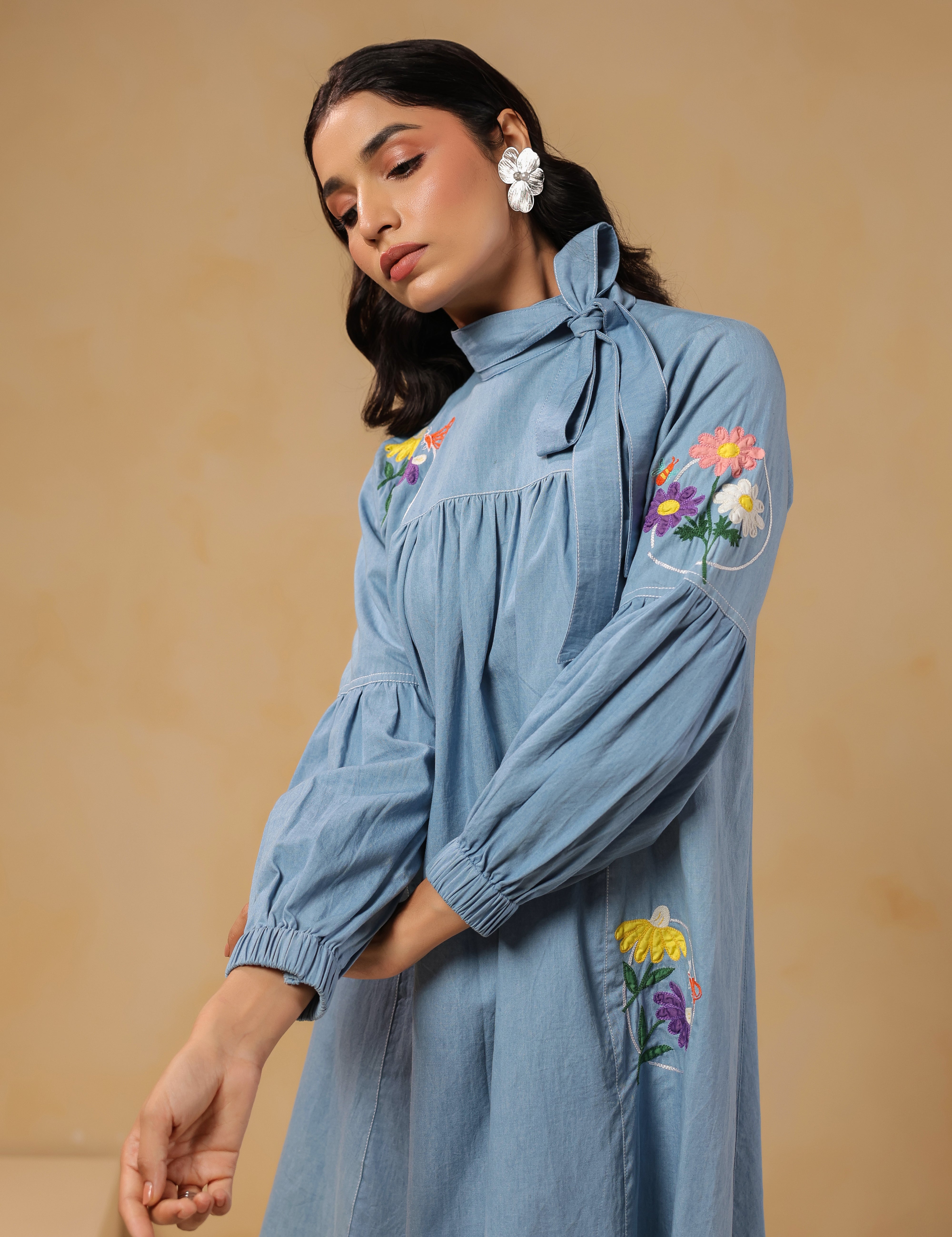 Close-up of floral embroidery and bow-tie neckline on Floraverse Denim Dress