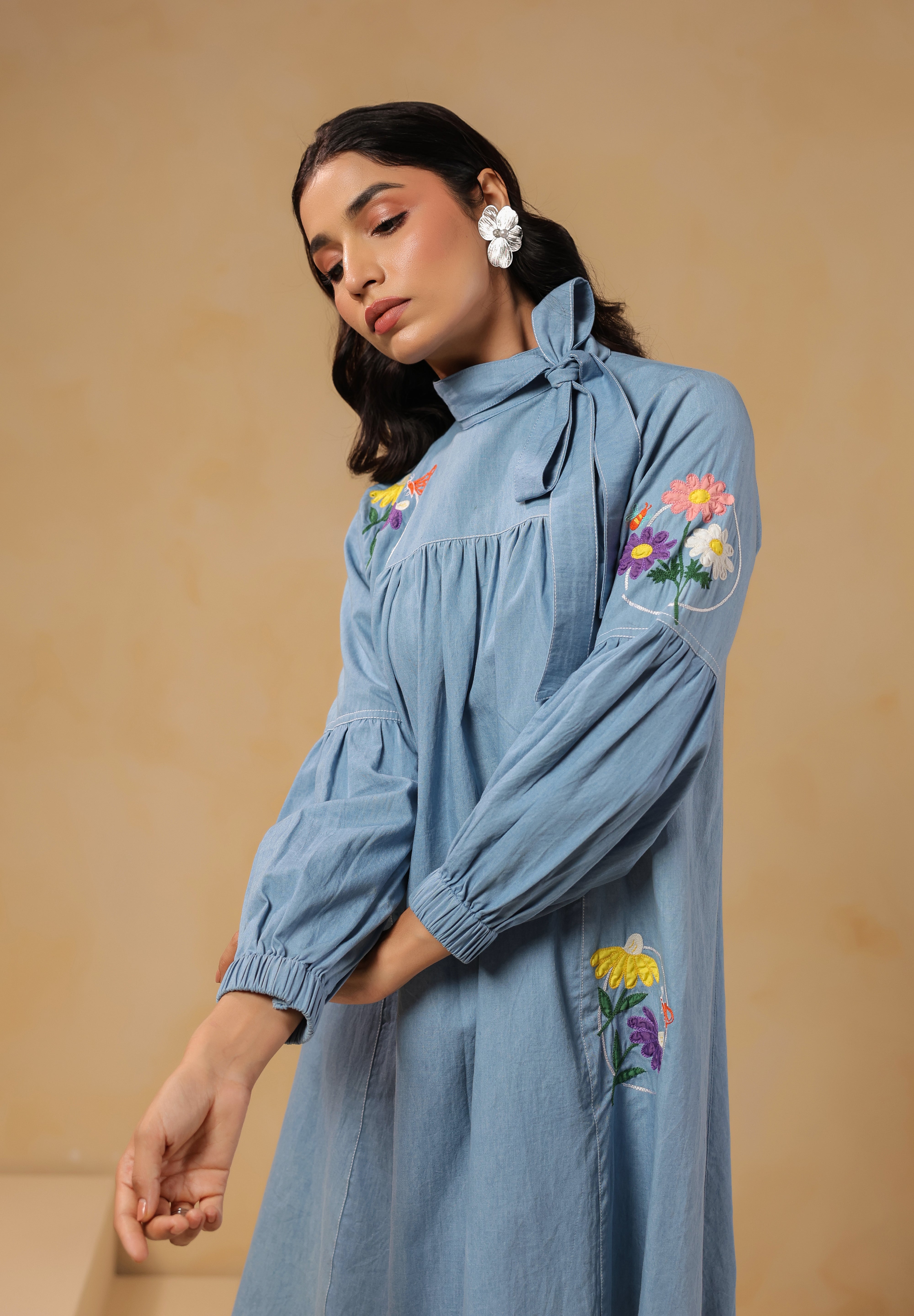 Close-up of floral embroidery and bow-tie neckline on Floraverse Denim Dress