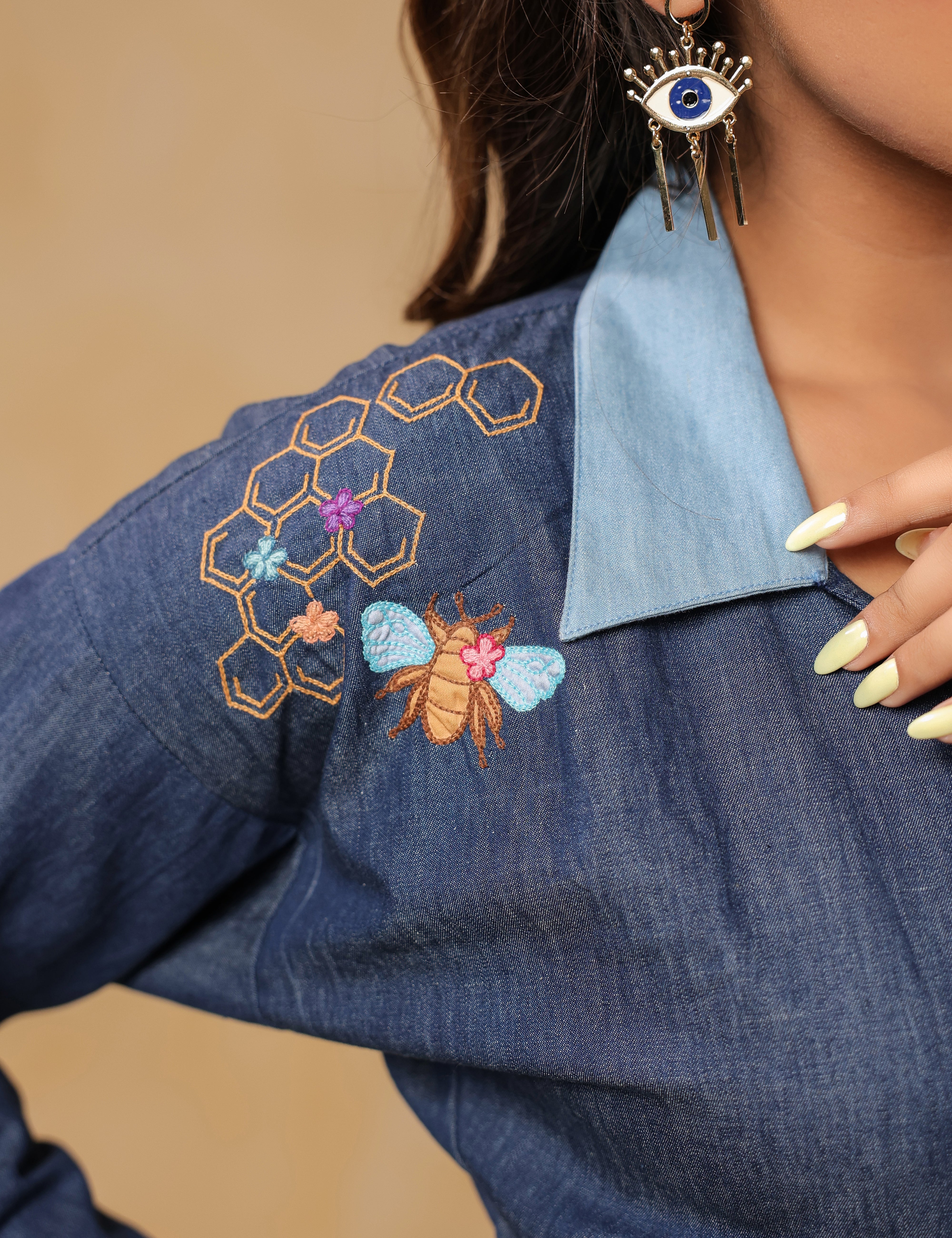 Close-up of shoulder embroidery with honeycomb and honeybee detailing on Hexabee Wrap Top