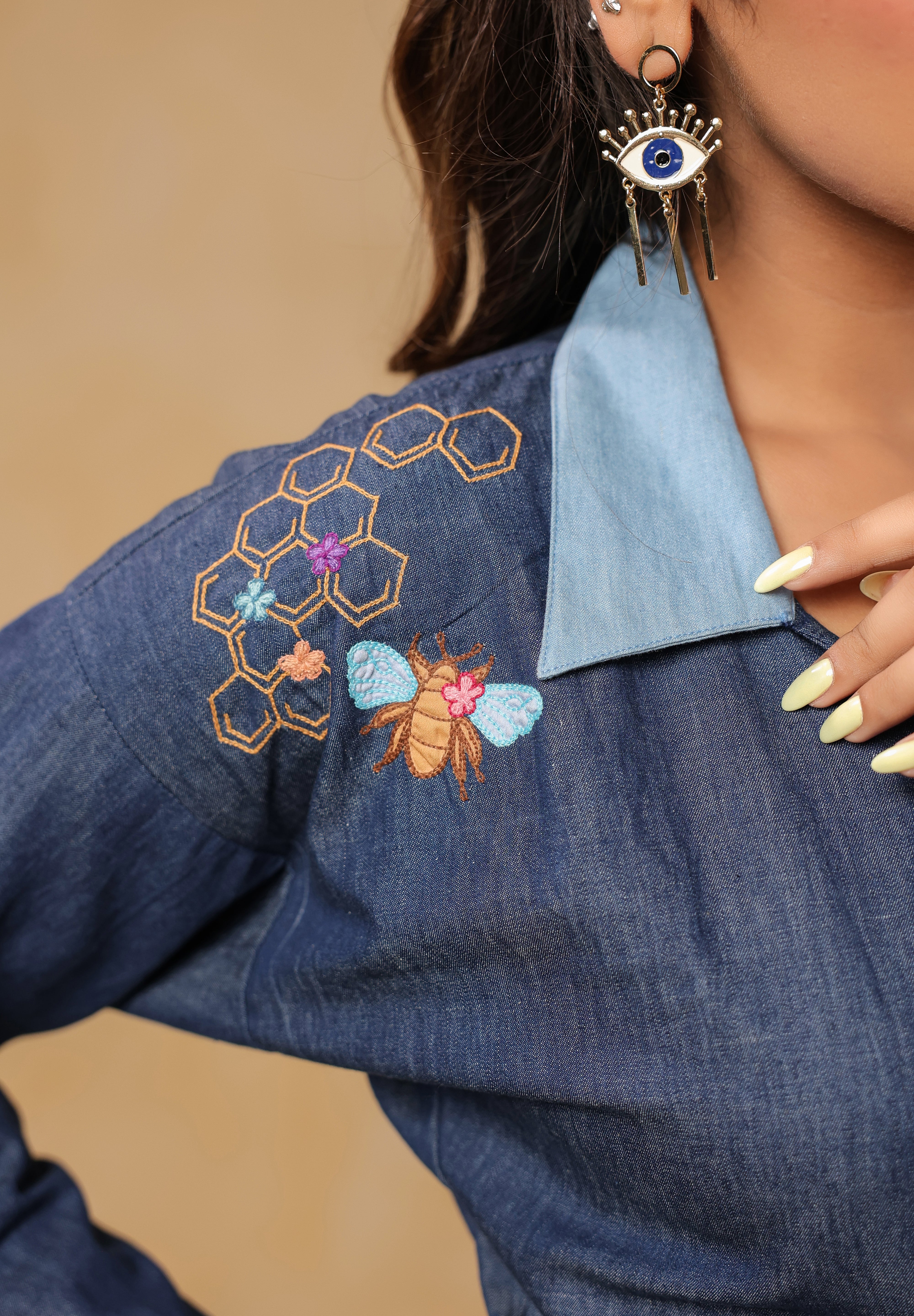 Close-up of shoulder embroidery with honeycomb and honeybee detailing on Hexabee Wrap Top