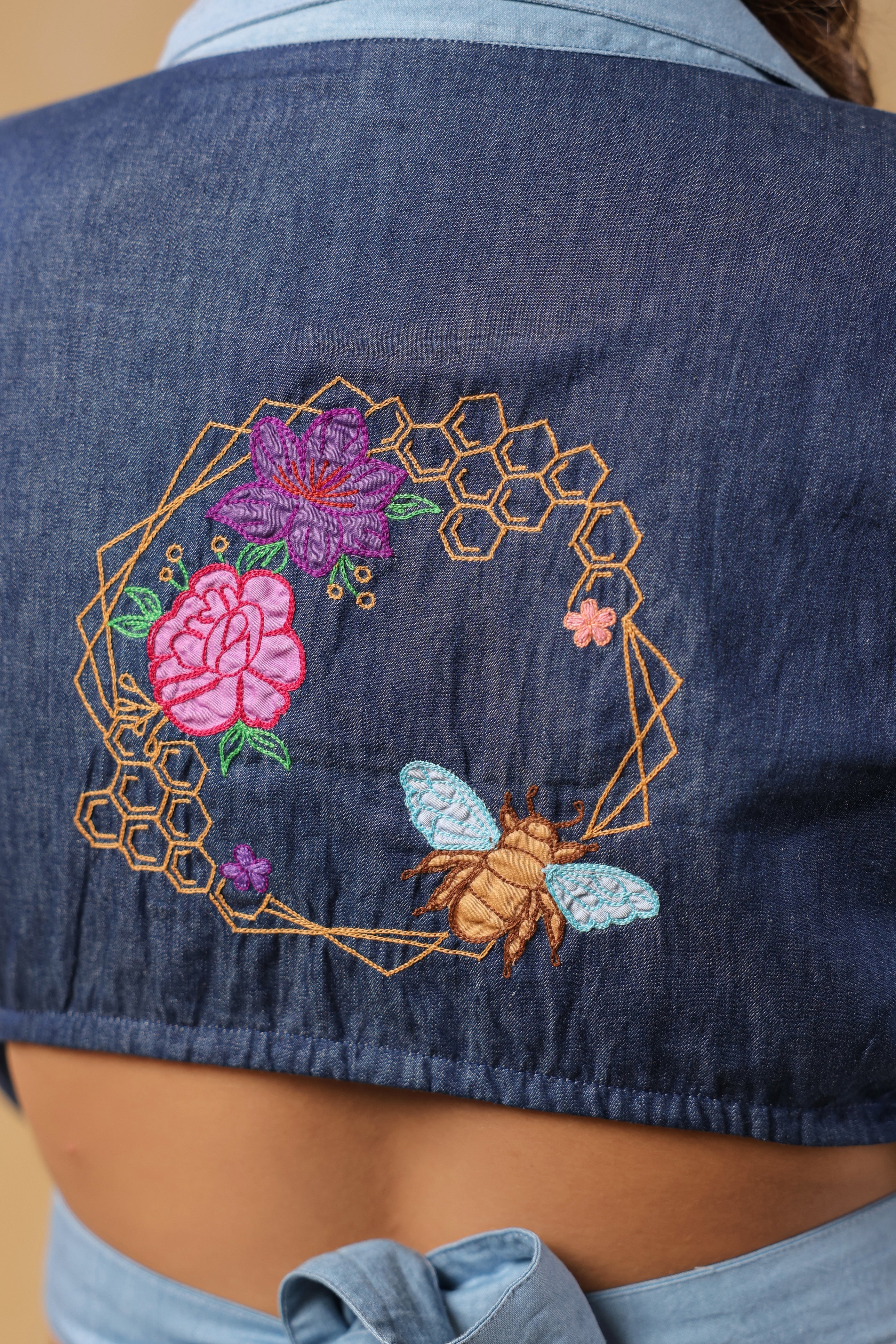 Detailed embroidery on the back of Hexabee Wrap Top with floral and bee accents