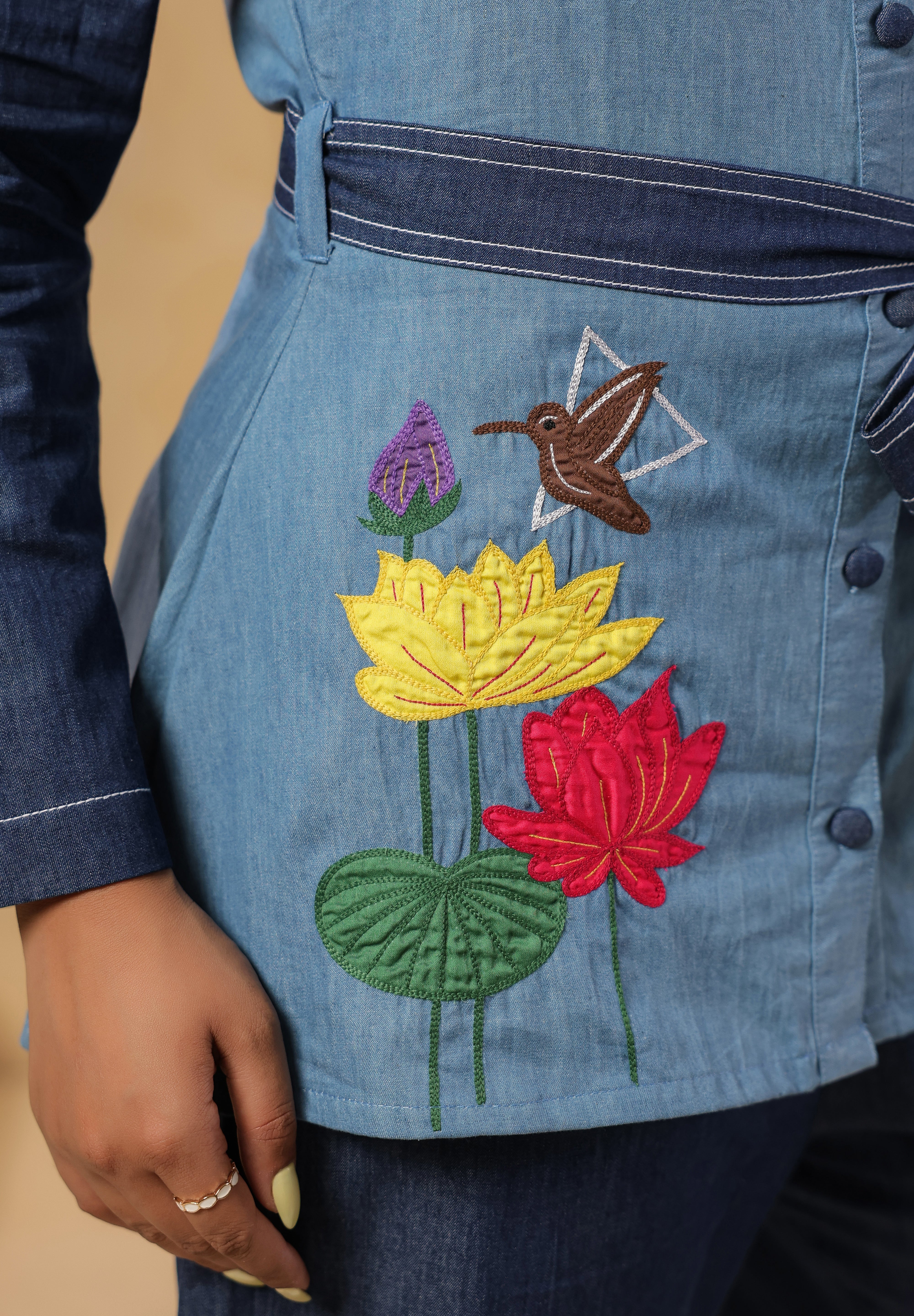 Detailed shot of blooming lotus embroidery with hummingbird motif on breathable denim — highlighting Ridah's celebration of flora in the Natureverse collection.