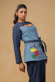 Zoomed view of structured neckline and bold cutout detail on Ridah's denim top — adding edge to elegance in the Hummingbloom Coord Set.