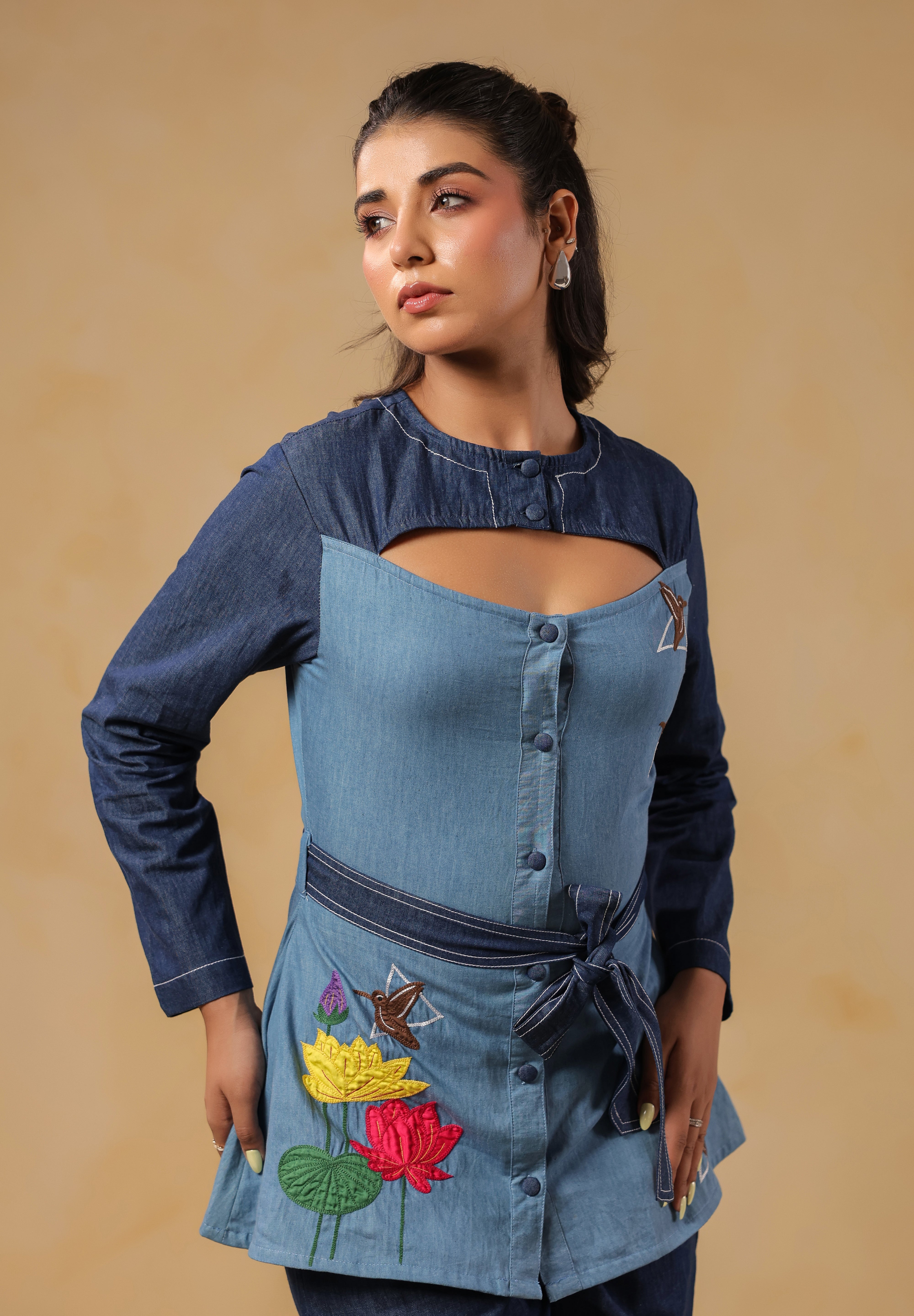 Signature Ridah tilt showcasing the Hummingbloom Shirt's fitted silhouette, vibrant embroidery, and versatility for expressive everyday style.
