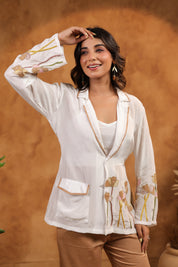 Woman wearing a white embroidered blouse with a brown background