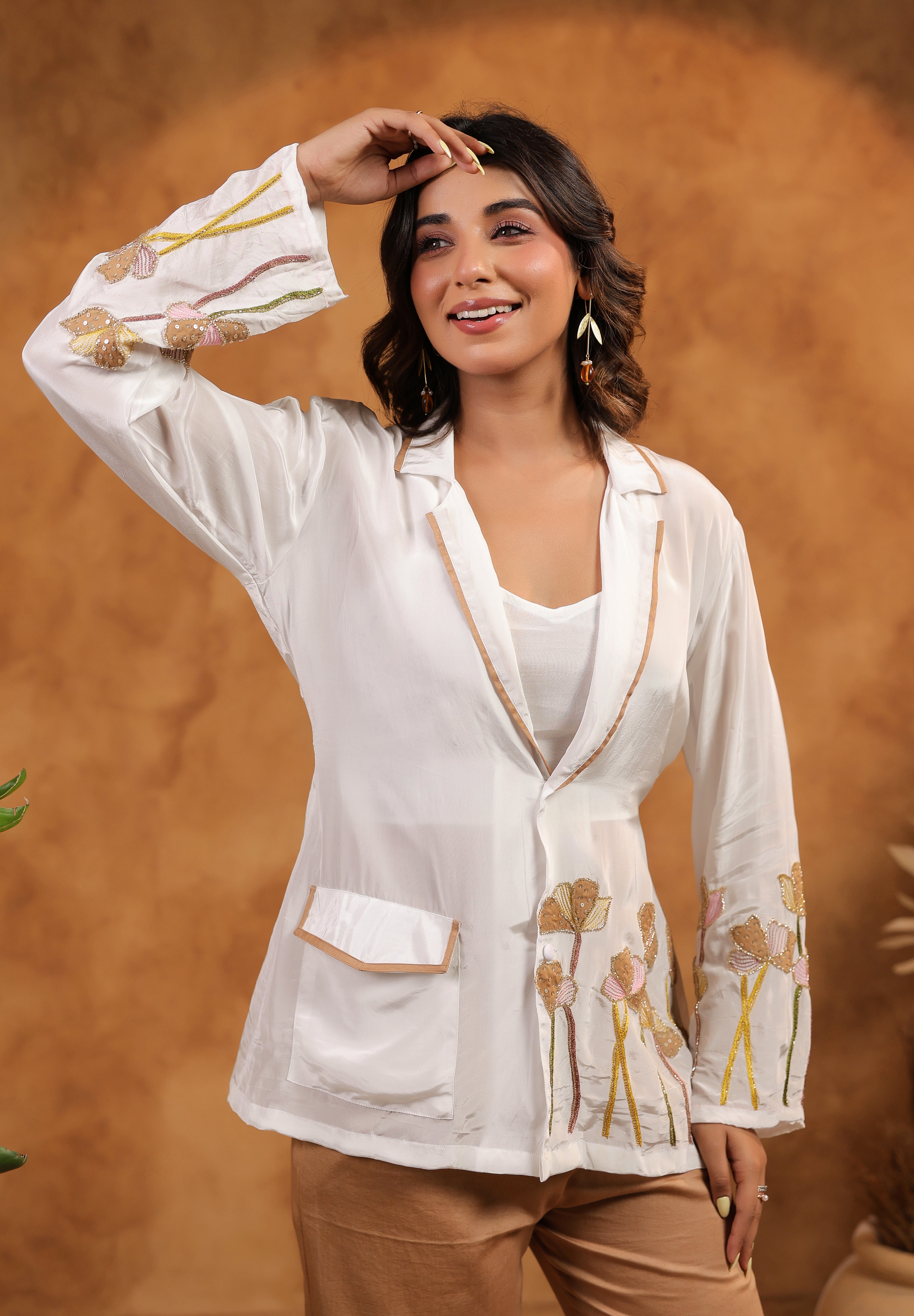 Woman wearing a white embroidered blouse with a brown background