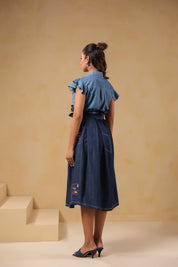 Back view of Ridah’s Meadowflair Coord Set featuring flutter sleeves and pleated A-line skirt with embroidered patchwork pockets — playful yet poised.