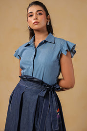Close-up of Ridah's collared flutter-sleeve top in soft denim — designed for breathable elegance and body-positive confidence.