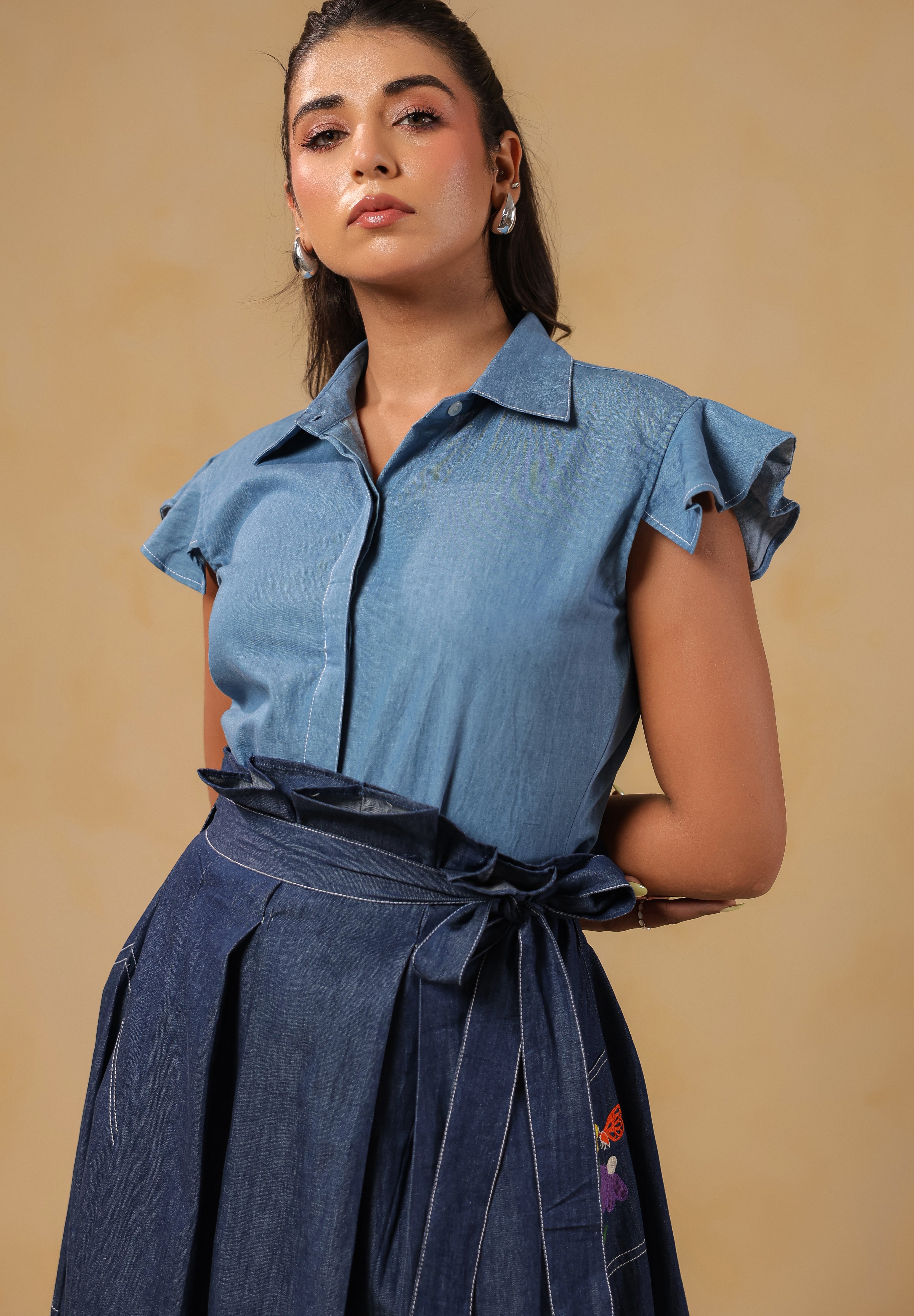Close-up of Ridah's collared flutter-sleeve top in soft denim — designed for breathable elegance and body-positive confidence.