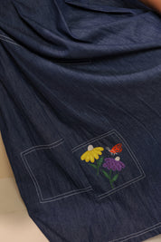 Close-up of pocket patch embroidery featuring yellow and purple florals with an orange butterfly — inspired by meadows in bloom.