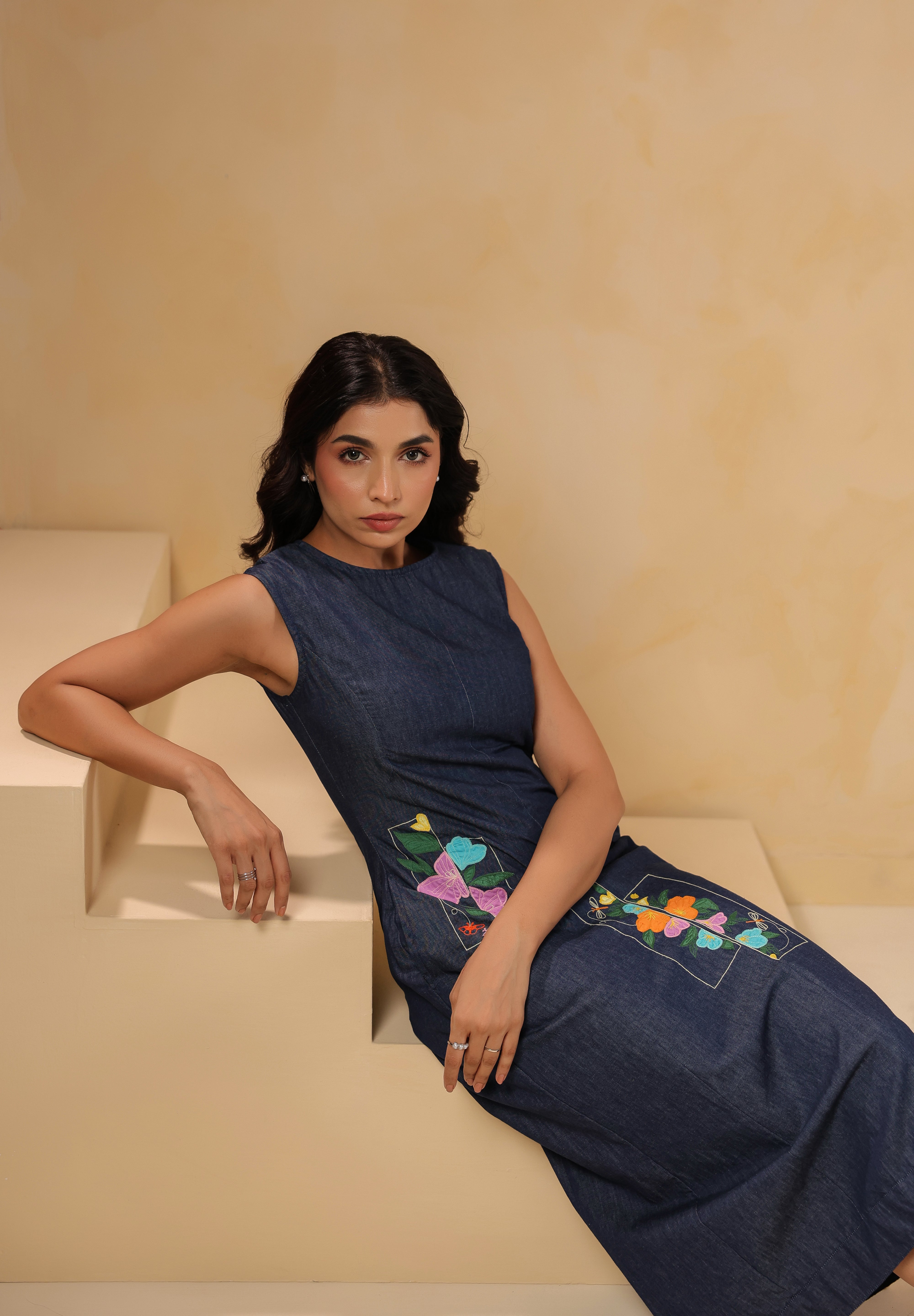 Seated look of Rectaflora Midi Dress in denim with panels.