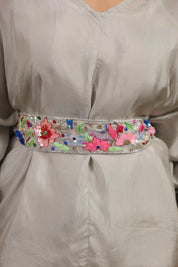 Decorative belt with floral and butterfly patterns on a plain garment.