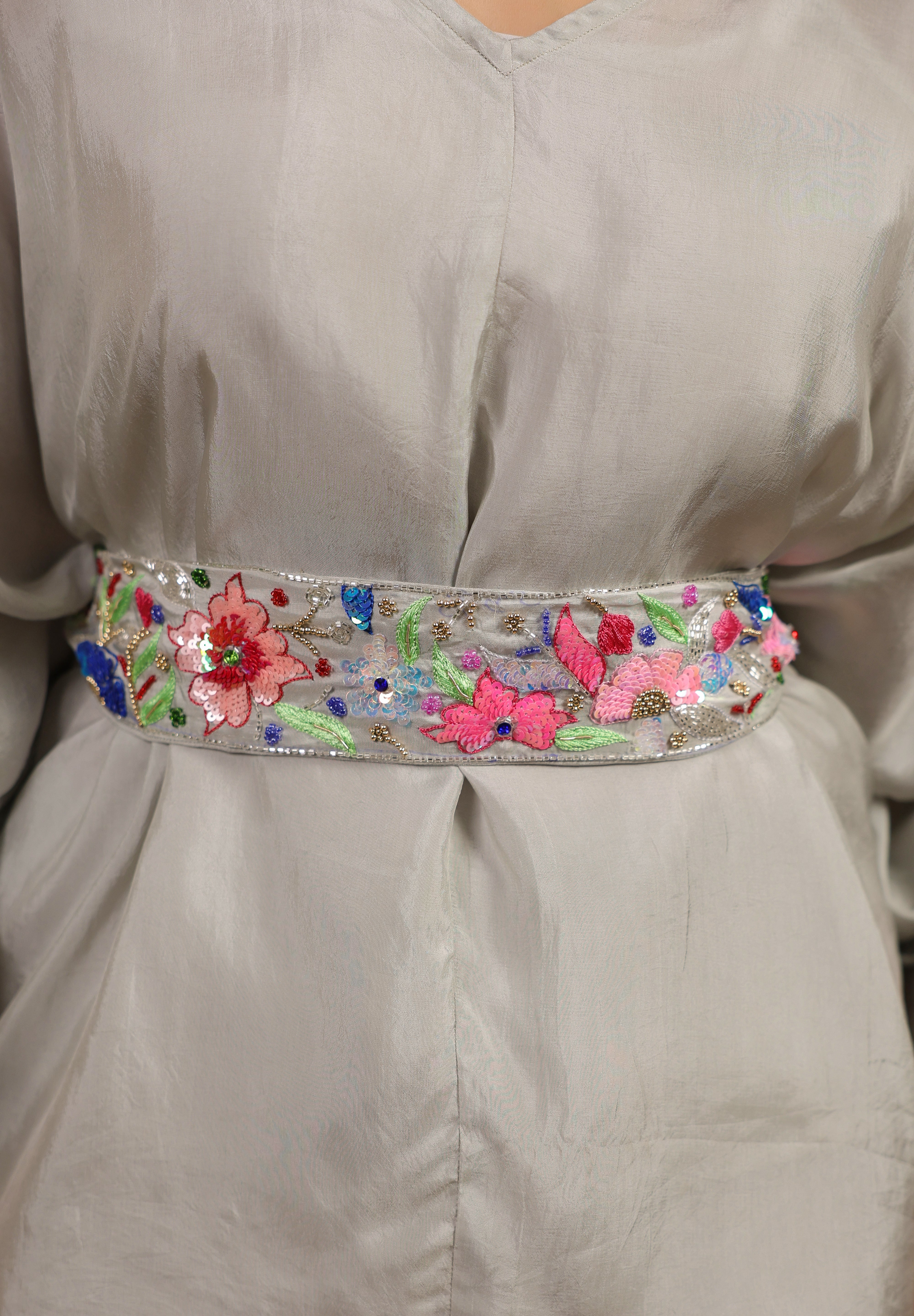 Decorative belt with floral and butterfly patterns on a plain garment.