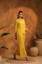 Relaxed smile with front-facing pose, emphasizing the colorful threadwork near the waistline.