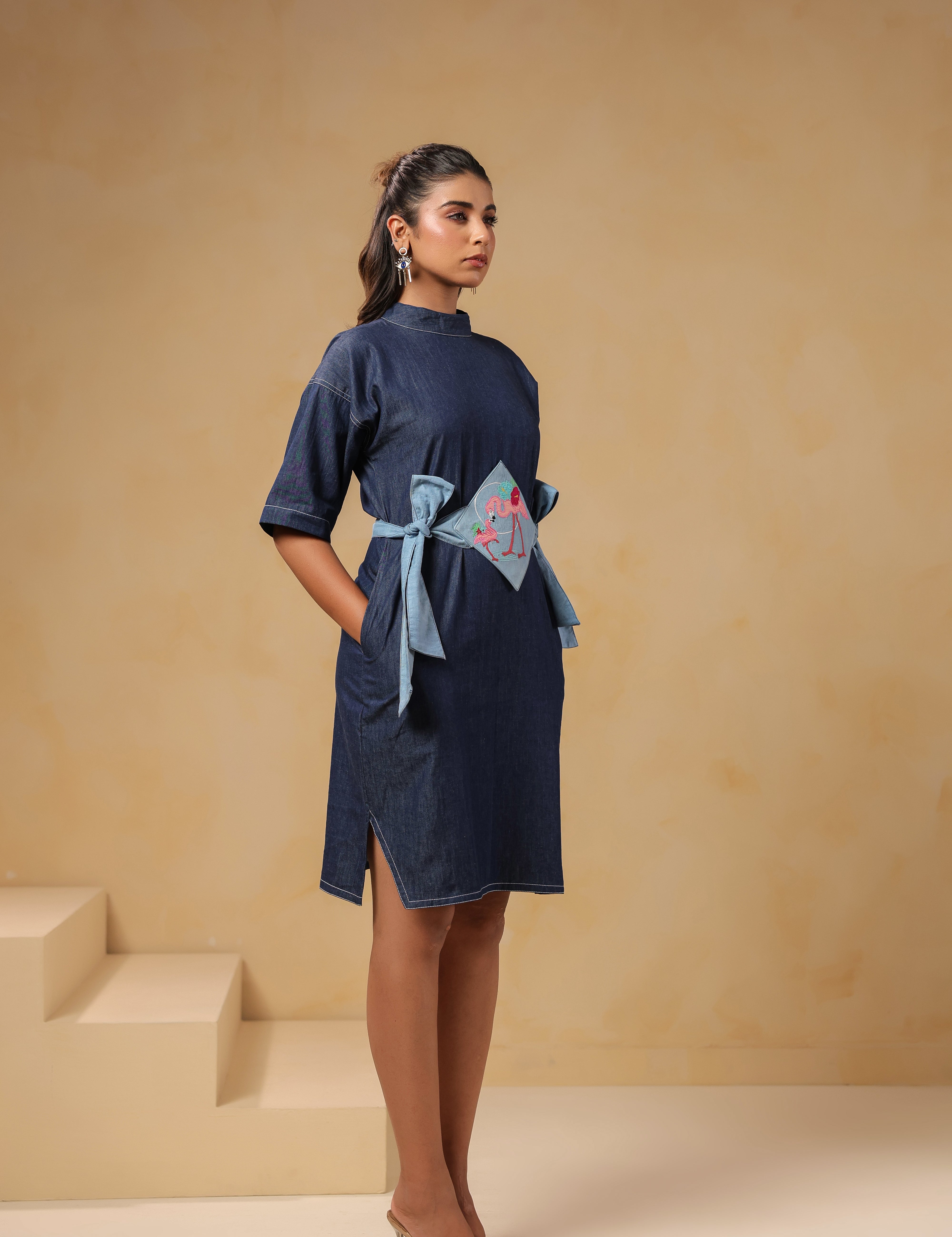 Diagonal view of Tide & Ties Flamingo Dress showing tie-up waist and flamingo motif