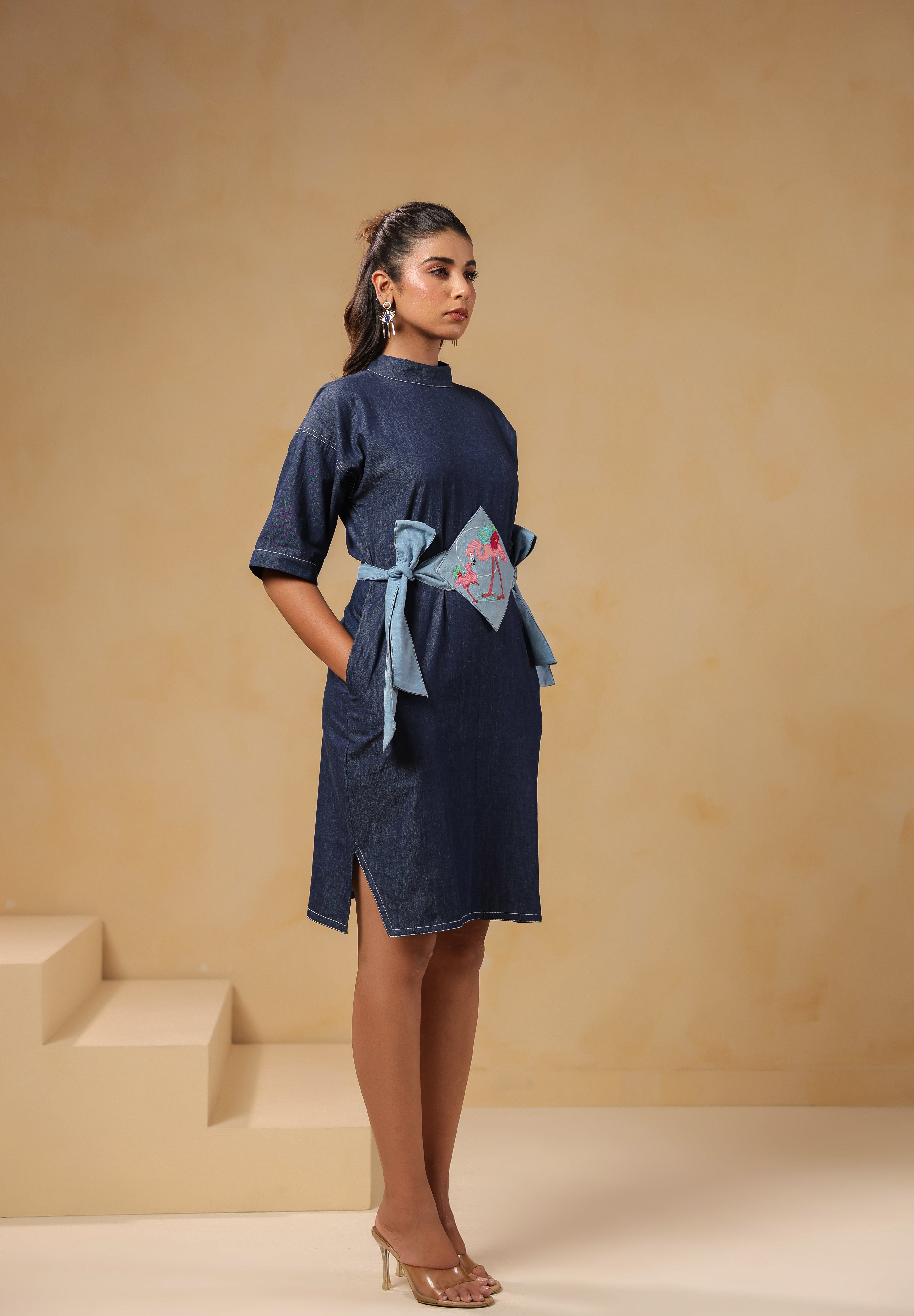 Diagonal view of Tide & Ties Flamingo Dress showing tie-up waist and flamingo motif