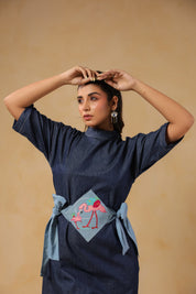 Zoomed-in embroidery of mother and baby flamingo on Tide & Ties Denim Dress