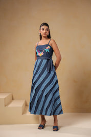 Front view of Turtletide Flare Dress, sleeveless denim midi dress with spiral panel detailing and colorful turtle-and-floral embroidery on bodice
