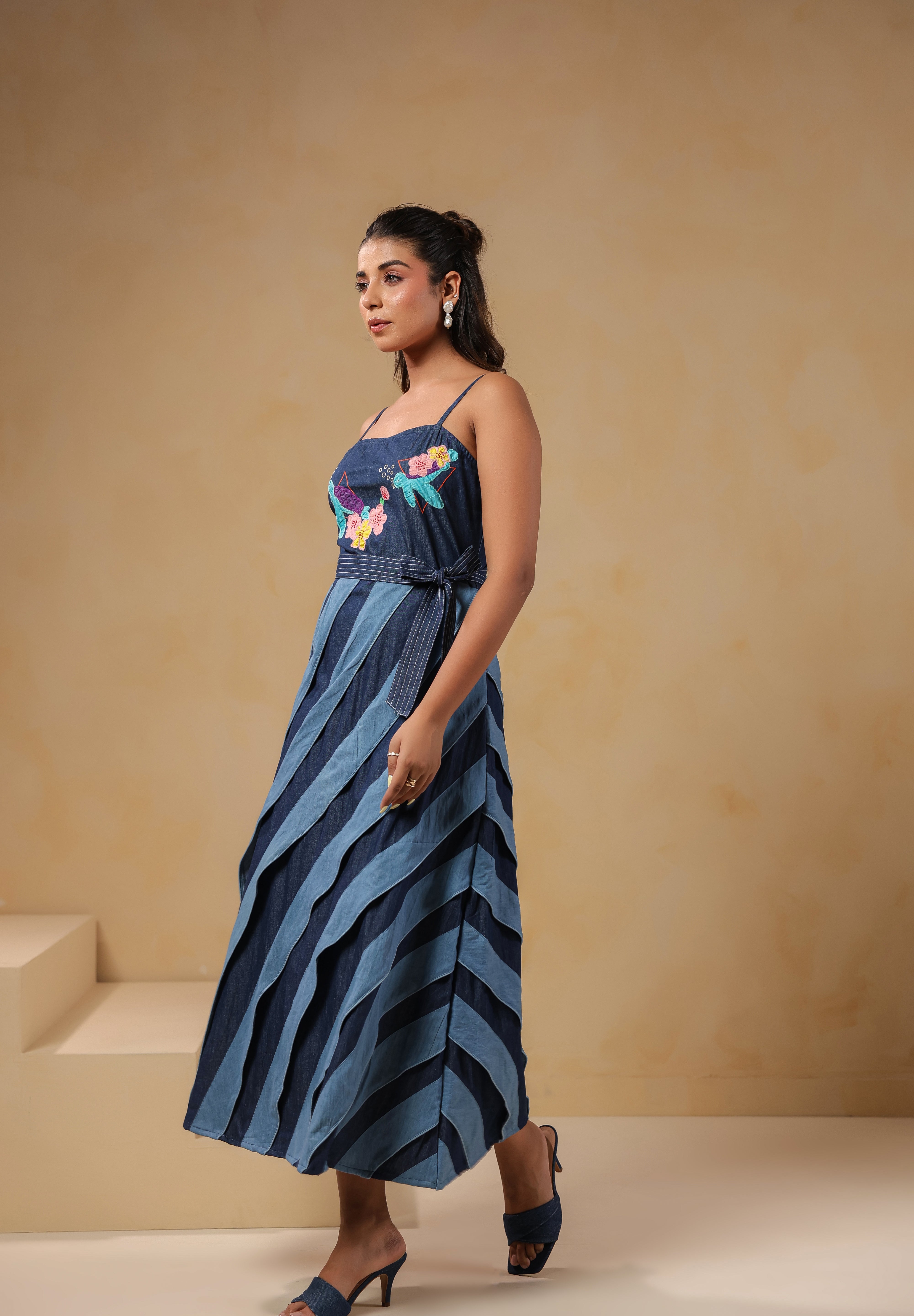 Model walking in Turtletide Flare Dress showcasing fluid spiral flare movement and embroidered details