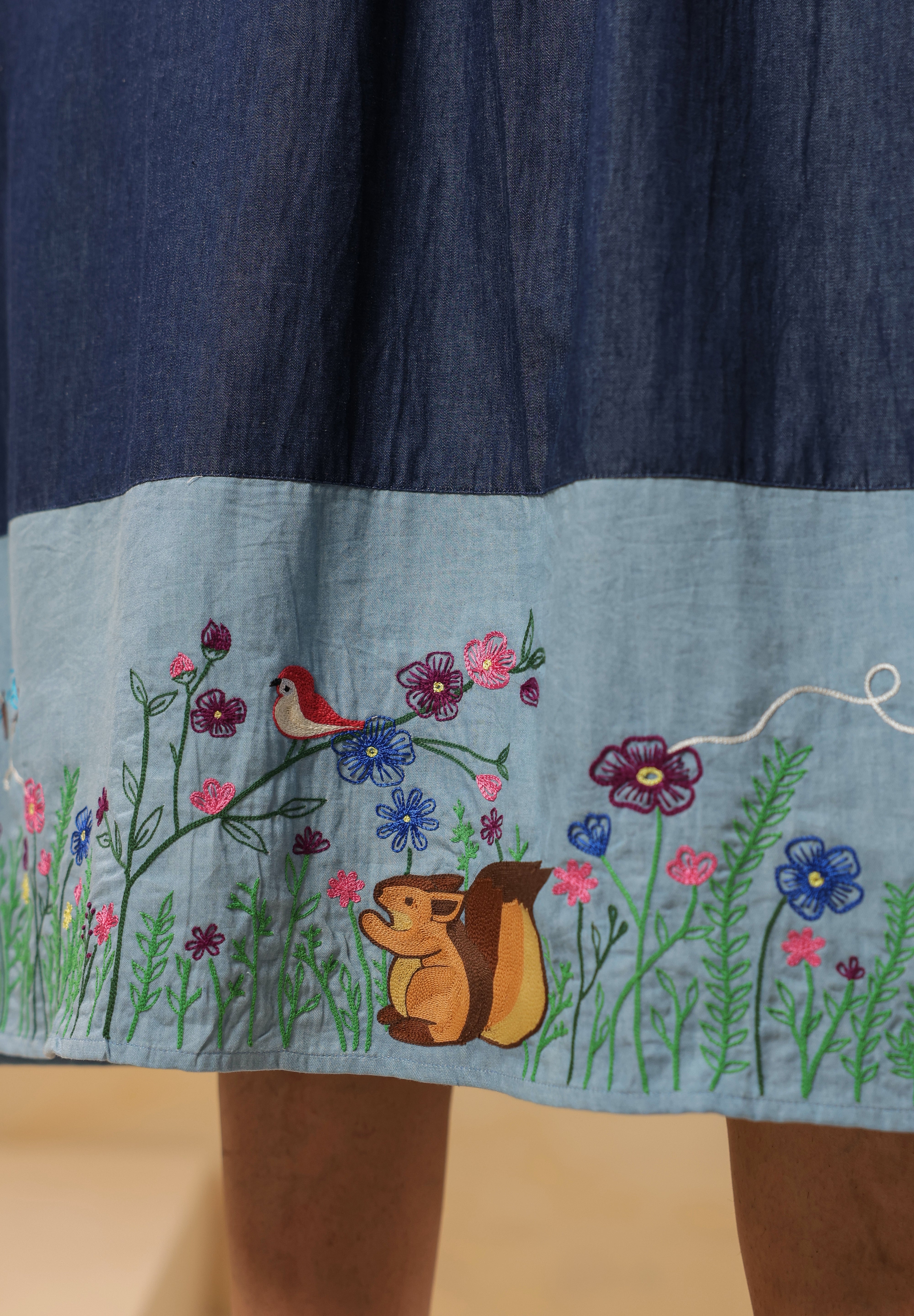 Detailed embroidery of flowers, butterflies, and chipmunk motif on Woodland Muse Midi Dress